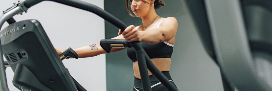 Vrouw op fitnesapparaat